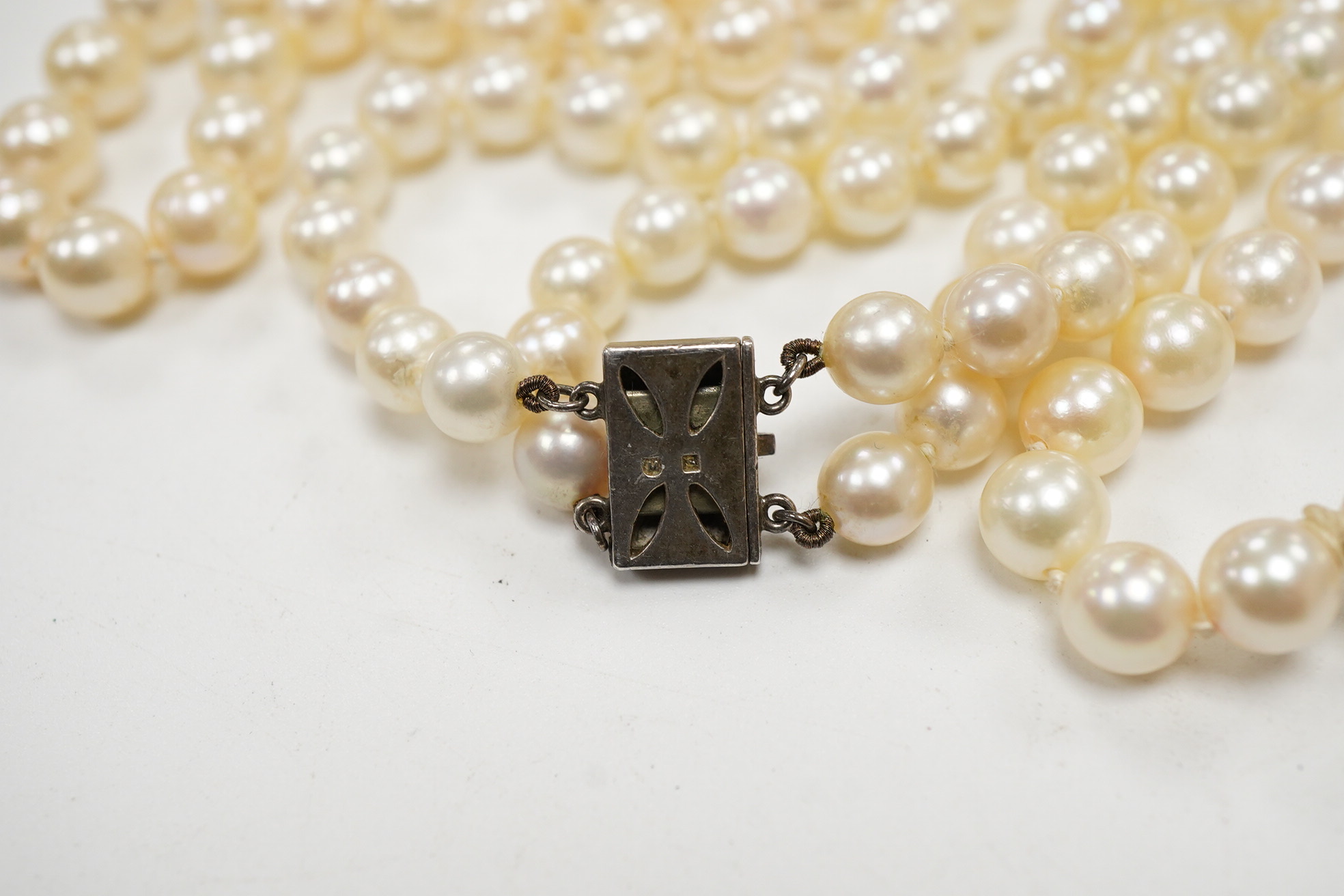 A Mikimoto double strand cultured pearl choker necklace, with cultured pearl set white metal clasp, 38cm, together with a single strand cultured pearl necklace, with cultured pearl set white metal clasp engraved 'silver'